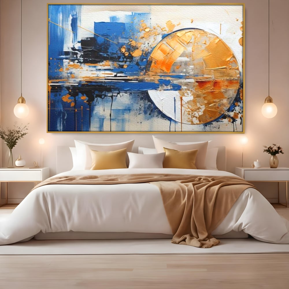 Tablou canvas cu pictura abstracta cu cerc auriu si albastru, in rama de aluminiu auriu, pe perete intr-un dormitor